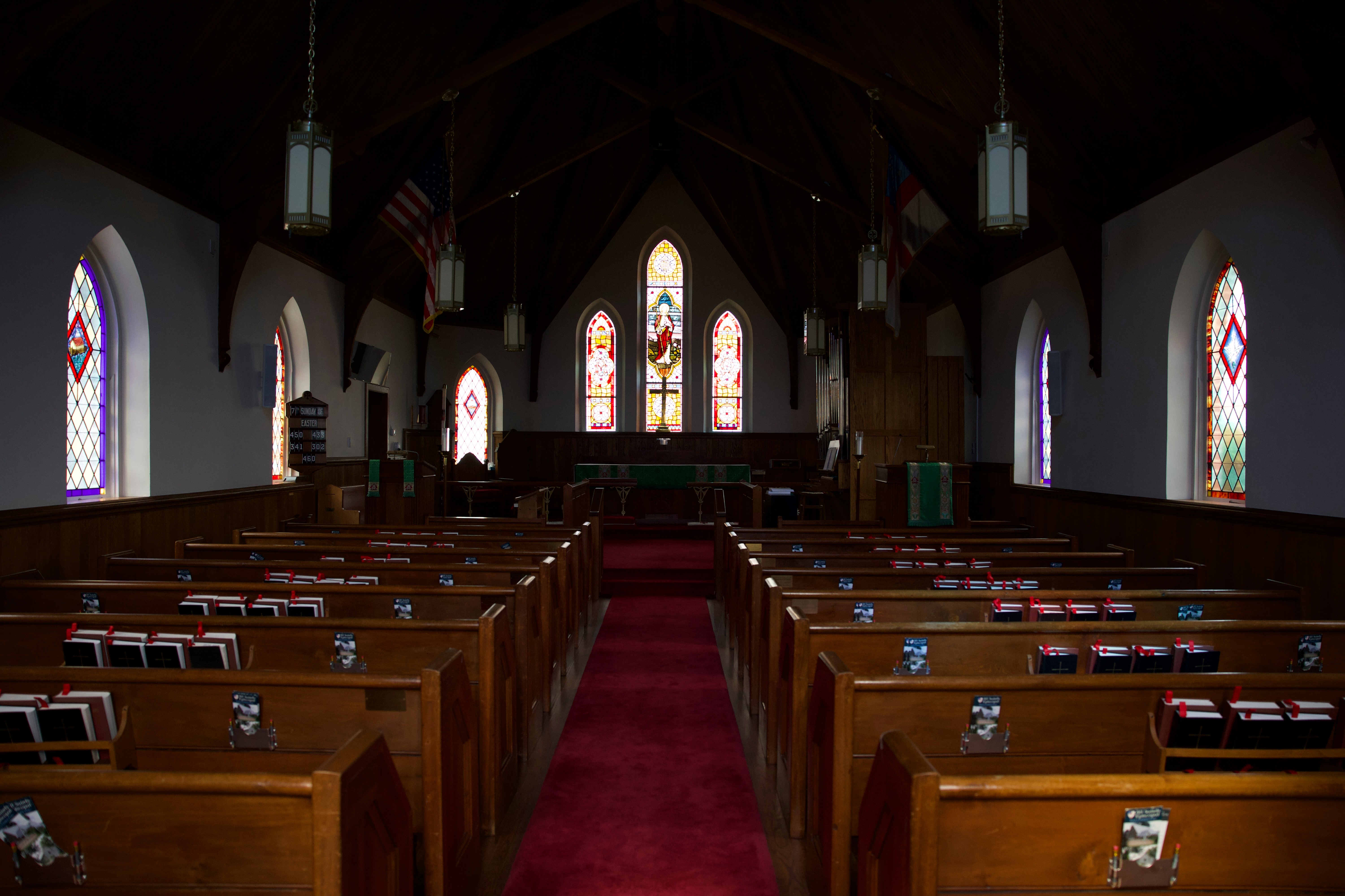 Interior of All Saints Episcopal Church looking down the aisle toward the altar with stained glass windows