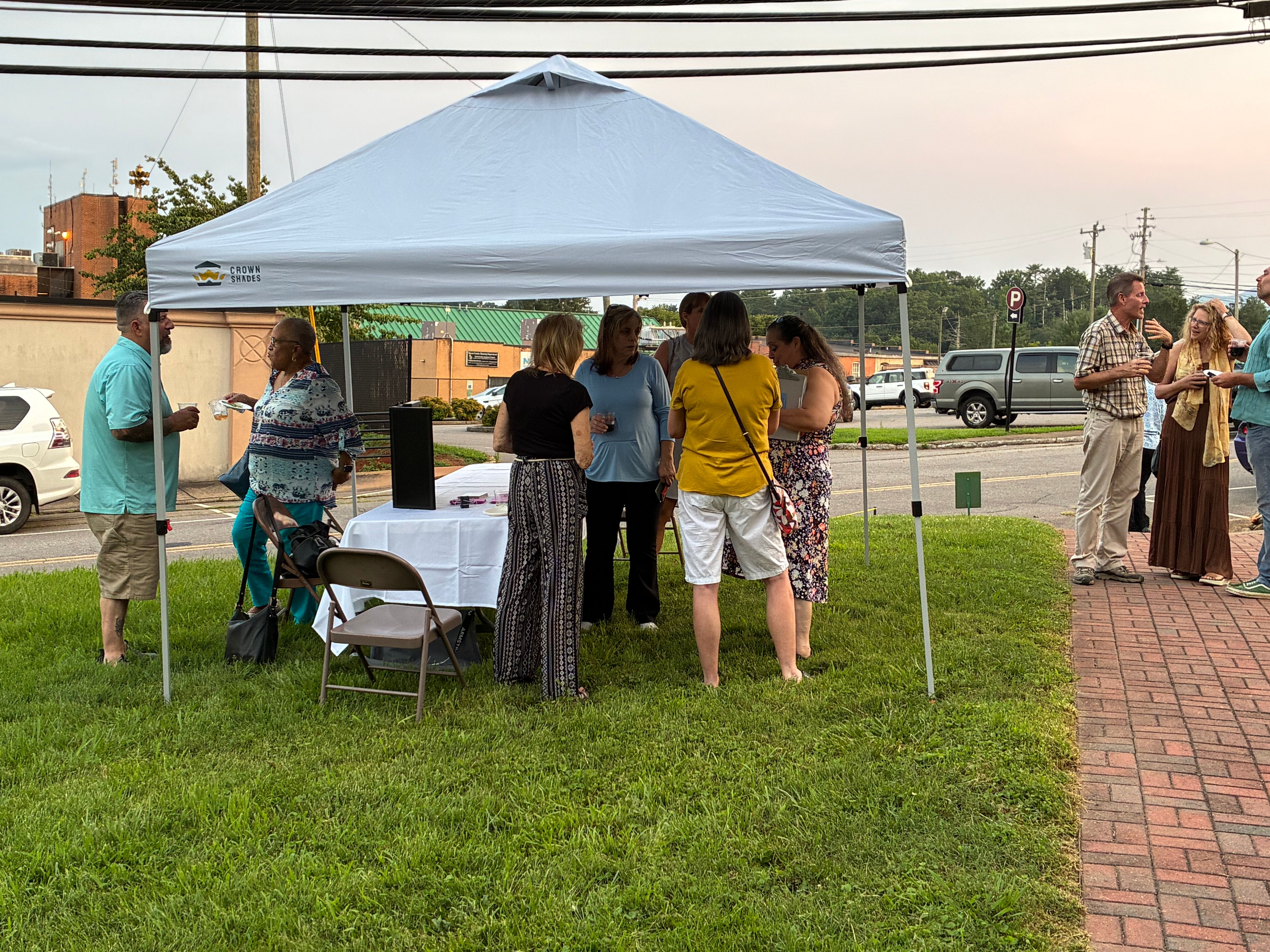 Guests gathered around a table under the canopy tent with downtown Franklin behind them