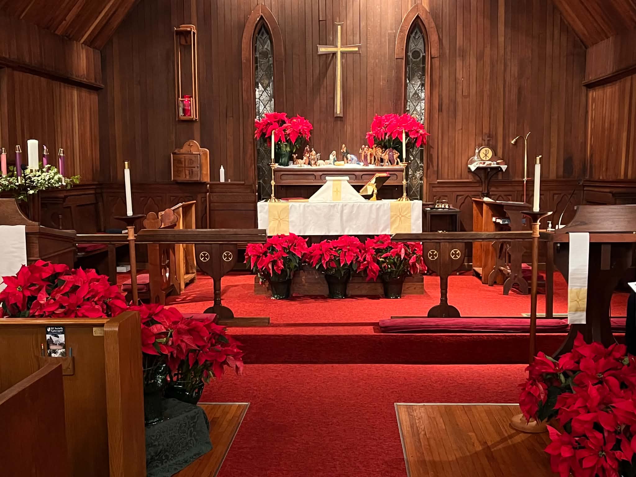 The altar decorated with red poinsettias and a nativity for Christmas