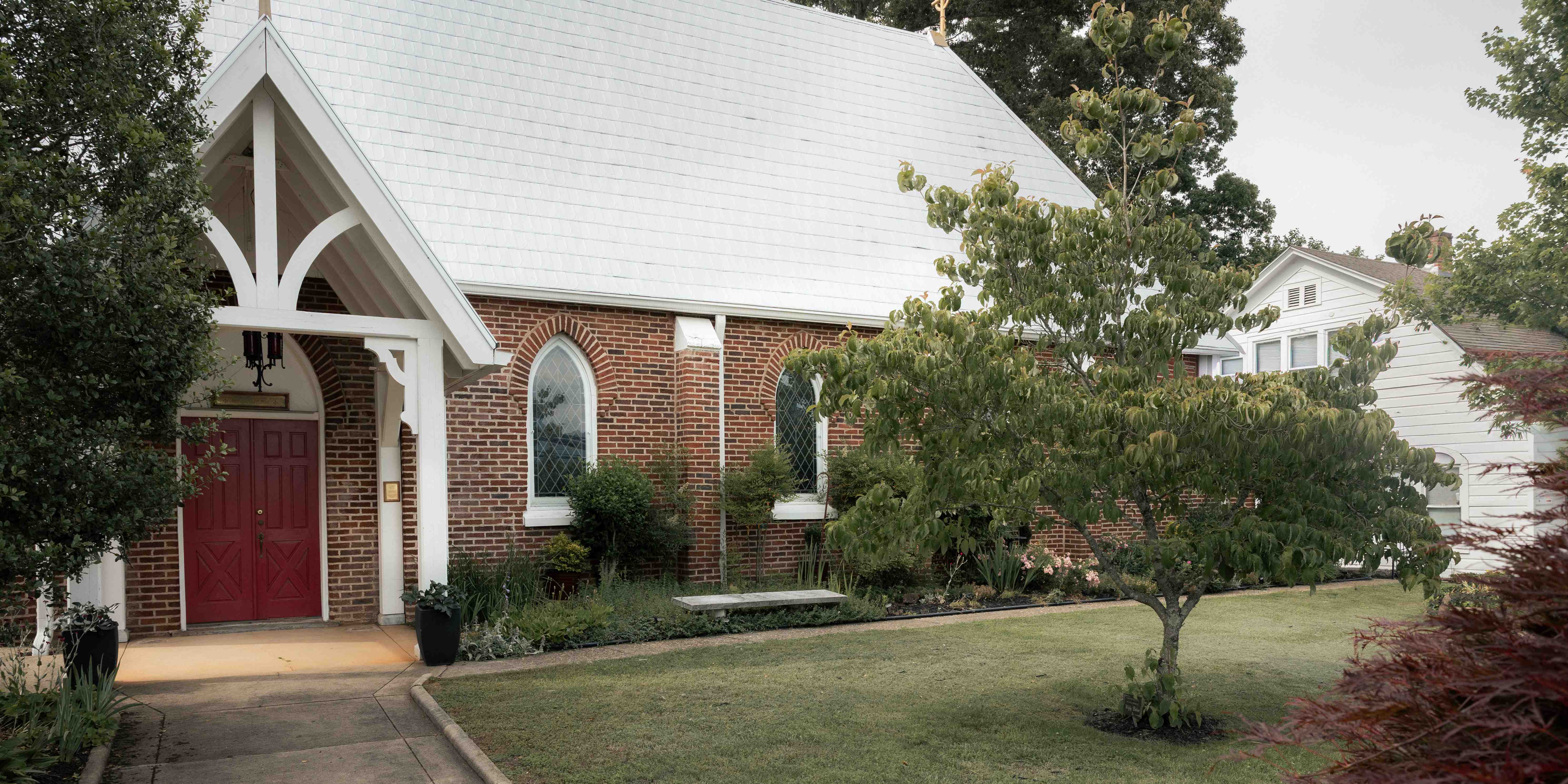 Chapel of Saint Agnes exterior close view with red doors and Gothic portico, Franklin NC